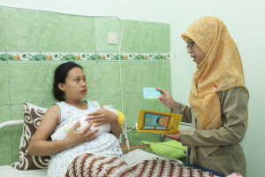 A post-delivery mother with a midwife, after cord blood has been collected