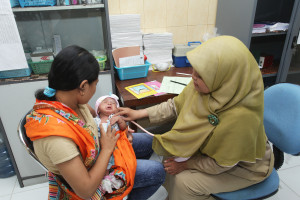 the PHC doctor was doing a medical examination to the baby who are having a mild acute respiratory infection episode and record the examination